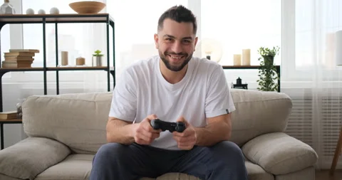 The man plays the TV game on sofa Stock Footage 150018197