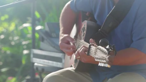 Man plays twelve string acoustic guitar during an outdoor party Stock Footage 136261586