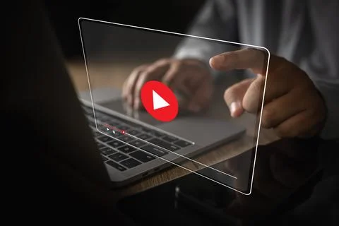 Man plays video media while watching a webinar on a laptop or screen techno.. Stock Photos