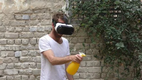 A man plays virtual augmented reality game against bugs Stock Photos