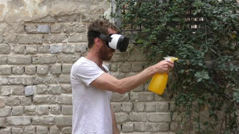 A man plays virtual augmented reality game against bugs Stock Photos