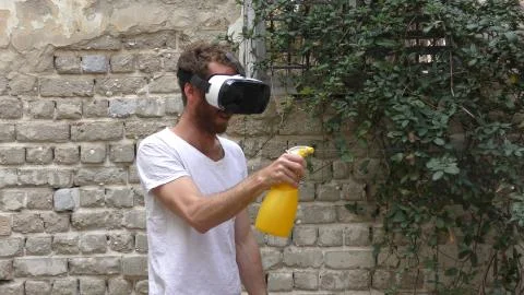 A man plays virtual augmented reality game against bugs Stock Photos