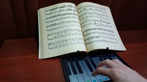 The man plays the virtual piano keyboard on notes close-up Stock Footage 106098706