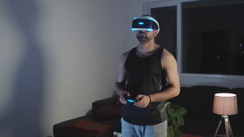 Man Plays Virtual Reality Game with Controller and Looks Around at Night Stock Footage 108881385