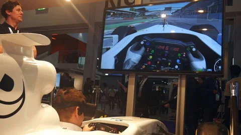 Man plays in a virtual reality racing game at ICE London, a B2B gambling event Stock Footage 102905445