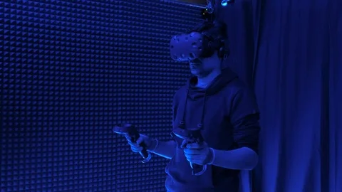 Man plays virtual reality using glasses, gamepad and headset. Stock Footage 117752460