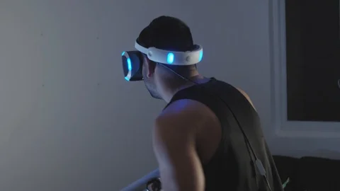 Man Plays Virtual Reality Video Game with Gun and Goggles in Living Room, Night Stock Footage 108880662