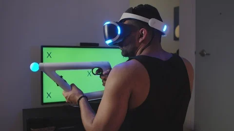 Man Plays Virtual Reality Video Game with Gun and Goggles, Green Screen Stock Footage 108880895