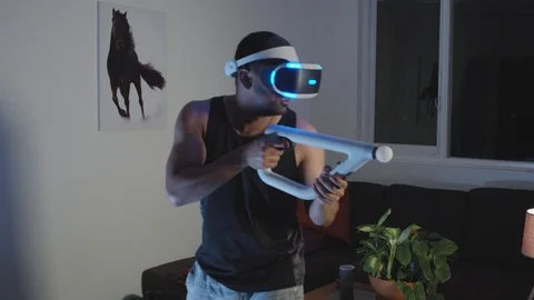 Man Plays Virtual Reality Video Game with Gun and Goggles in Living Room, Night Stock Footage 108881117