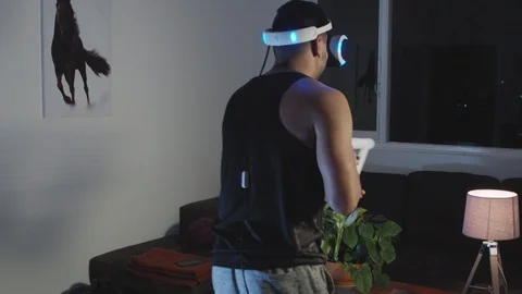 Man Plays Virtual Reality Video Game with Gun and Goggles in Living Room, Night Stock Footage 108881157