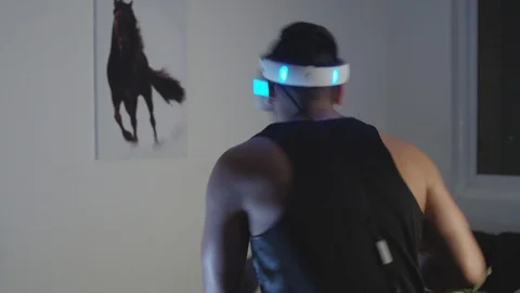 Man Plays Virtual Reality Video Game with Gun and Goggles in Living Room, Night Stock Footage 108881189