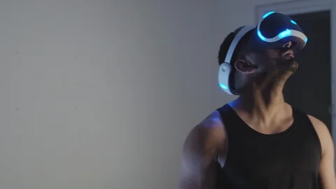 Man Plays Virtual Reality Video Game with Gun and Goggles in Living Room, Night Stock Footage 108881330