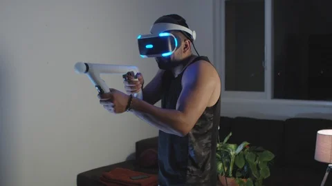 Man Plays Virtual Reality Video Game with Gun and Goggles in Living Room, Night Stock Footage 108881345