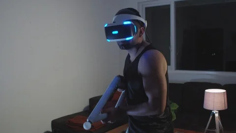 Man Plays Virtual Reality Video Game with Gun and Goggles in Living Room, Night Stock Footage 108881364