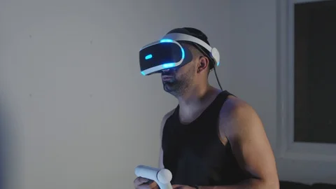 Man Plays Virtual Reality Video Game with Gun and Goggles in Living Room, Night Stock Footage 108881510