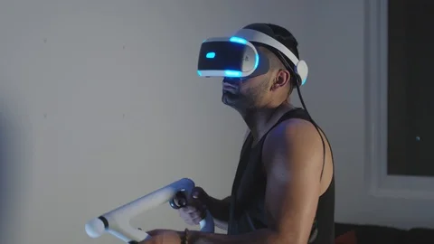 Man Plays Virtual Reality Video Game with Gun and Goggles in Living Room, Night Stock Footage 108881535