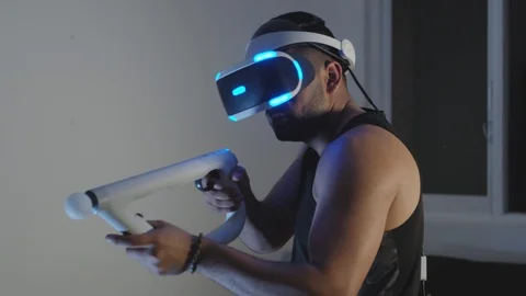 Man Plays Virtual Reality Video Game with Gun and Goggles in Living Room, Night Stock Footage 108881577