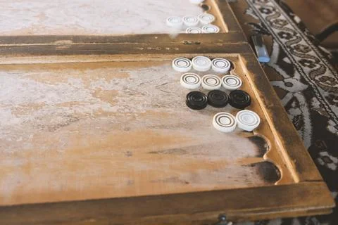 A man plays at a wooden table, backgammon Stock Photos