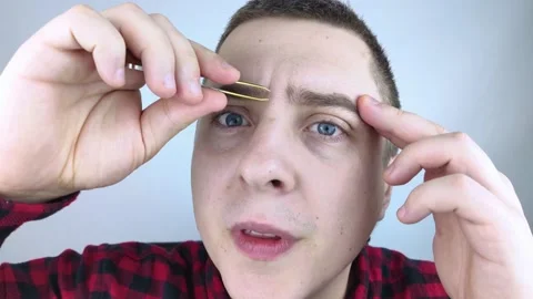 Man plucking eyebrows. Close-up of removing excess hair with tweezers. Isolated  Video stock 167255687