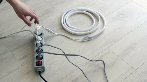 Man plug in socket Electrical Surge Protector and turn on the led strip Stock Footage 128228761