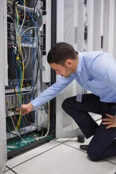 Man plugging a cable into server Stock Photos