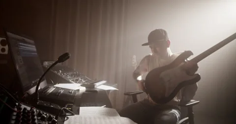 Man plugging in cord and playing guitar in studio Stock Footage 249913712