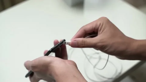 Man plugging earphone cable into smartphone Stock Footage 163862863