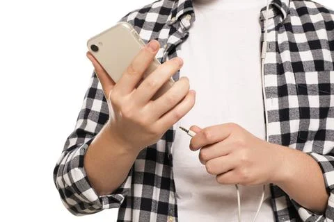 Man plugging headphones to smartphone on white background, closeup Stock Photos