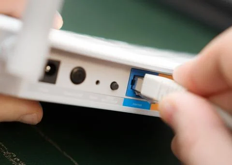 Man plugging internet cable into wifi router. Foto stock