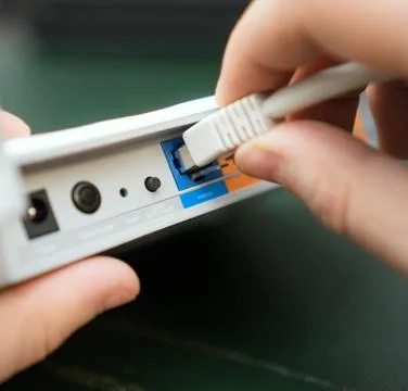 Man plugging internet cable into wifi router. Foto stock