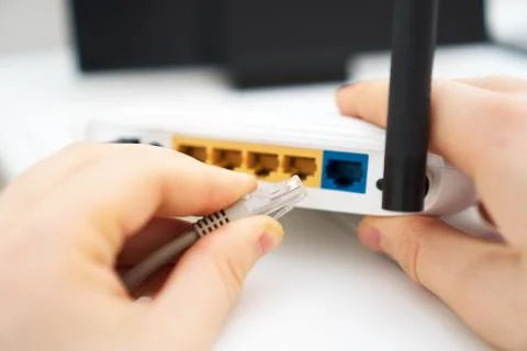 Man plugging internet cable into wifi router. Foto stock