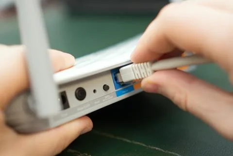 Man plugging internet cable into wifi router. Foto stock
