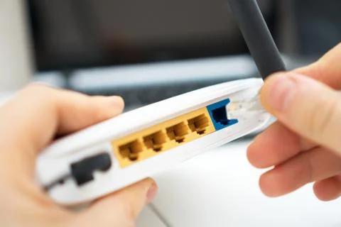 Man plugging internet cable into wifi router. Foto stock