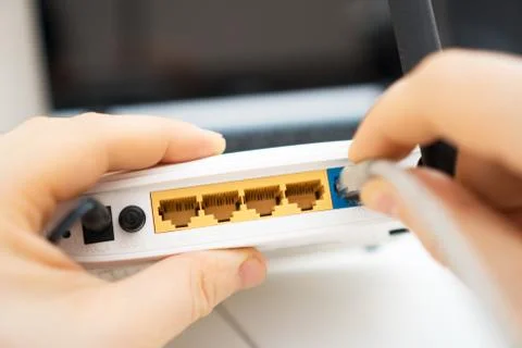 Man plugging internet cable into wifi router. Foto stock