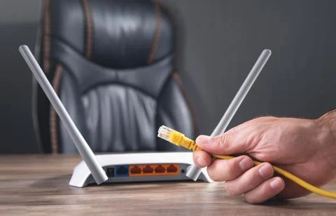 Man plugging internet cable into wifi router. Foto stock