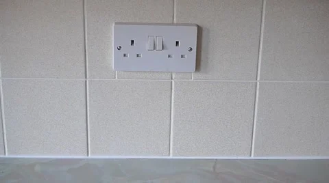 Man Plugging In a Three Pin UK Plug Into a Socket (Model Release) Stock Footage 1037408
