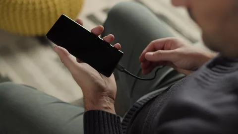 Man Plugging USB Cable into Smartphone Screen Video stock 346810342