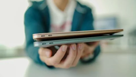Man plugging in white USB Type C cable into USB-C port on laptop 2 Stock Photos