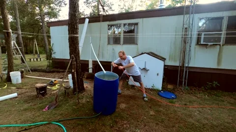 Man plugin electric pump and testing water flow going out of self made well Video stock 162853681