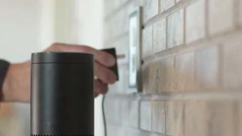 Man Plugs In Amazon Alexa Unit in Kitchen Stock Footage 86425724