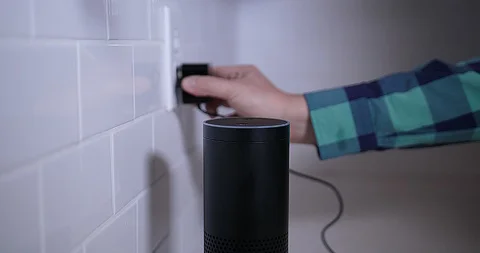 Man Plugs In Amazon Alexa Virtual Assistant Unit in Kitchen Stock Footage