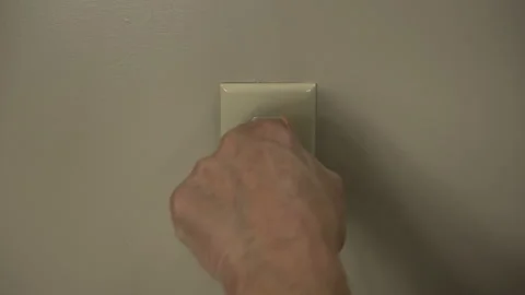 A man plugs a cord into a shorted electrical socket causing arcing and sparks Stock Footage 218402982