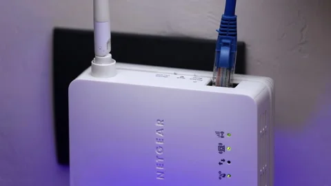 The man plugs the ethernet cable into the WiFi extender Stock Footage 171007053