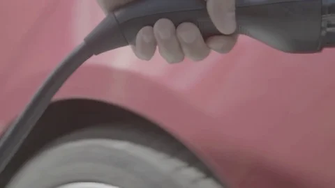 Man plugs in red Tesla Stock Footage 74696132