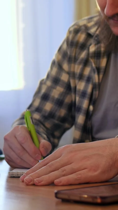 Man pocketing thoughts through writing. Quiet scene of man composing thoughts on Stock-Footage 344720240