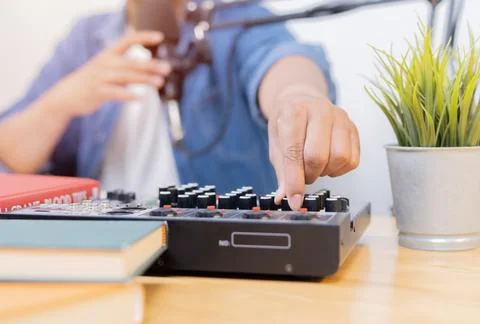 Man in the podcast studio adjust the equalizer or sound processor Stock Photos