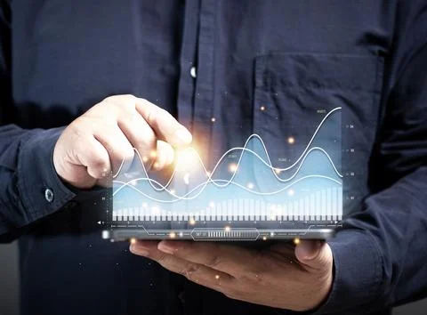 Man point out the intersection of bar graphs in deciding to buy stocks at a.. Stock Photos
