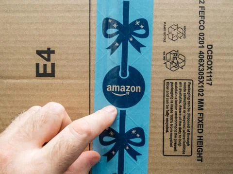 Man pointing to the Amazon Prime winter holiday logotype on parcel Foto stock