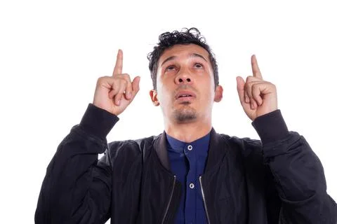 Man pointing up with both hands, white background. Young adult Latino young man Stock Photos