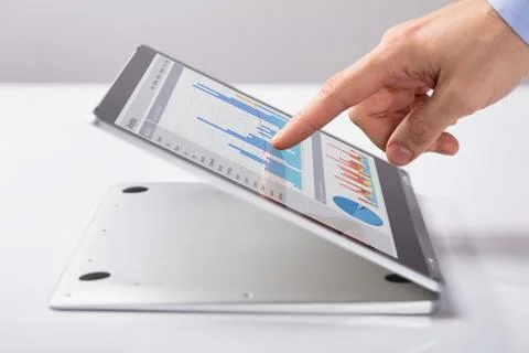 Man Pointing At The Business Graph On Hybrid Laptop Stock Photos